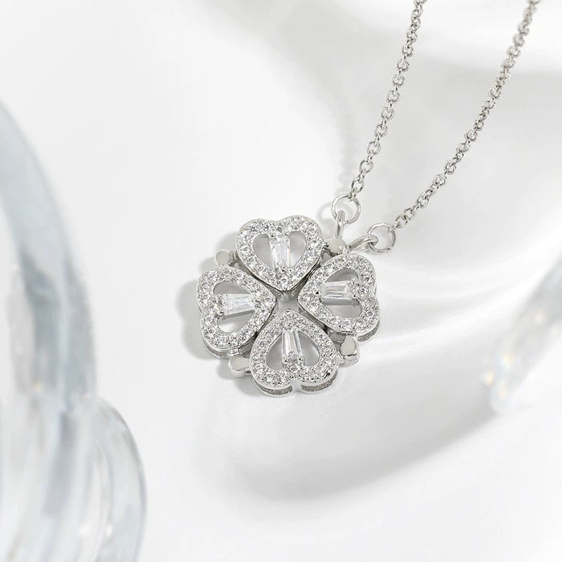 Silver necklace with a clover-shaped pendant on a white background