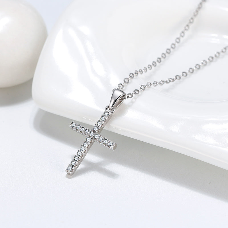 Silver cross pendant necklace on a white background