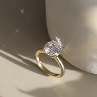 Gold ring with a diamond CZ on a neutral background