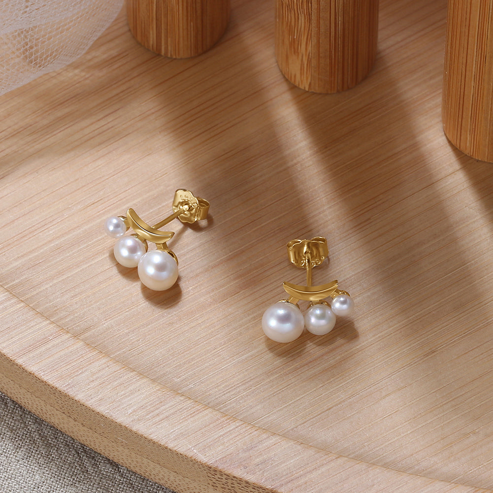 Gold vermeil earrings with pearls on a wooden surface