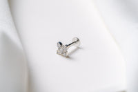 A gold earring in a star shape featuring cubic zirconias on a white background