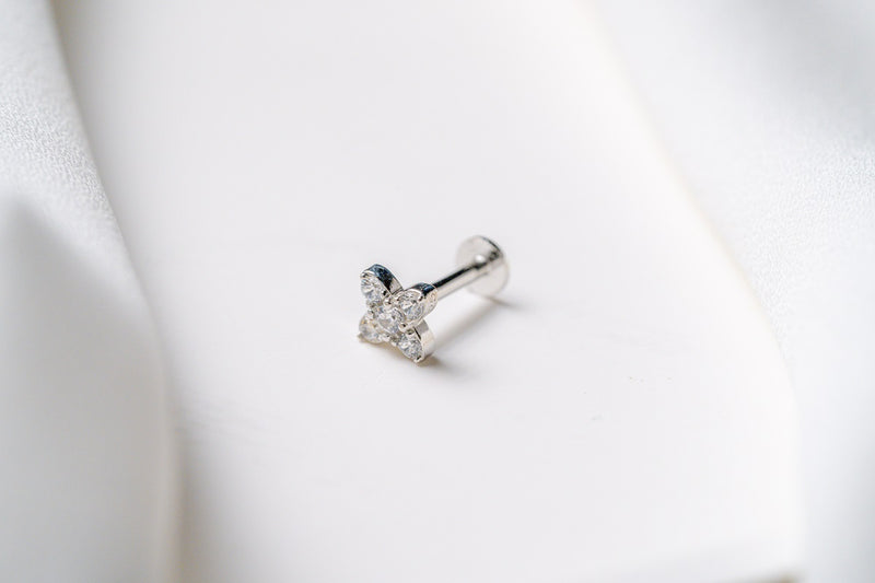 A gold earring in a star shape featuring cubic zirconias on a white background