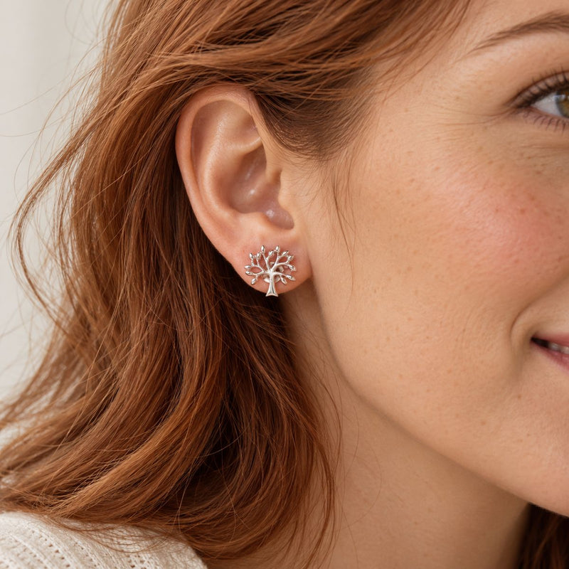 tree of life stud earrings worn by a model