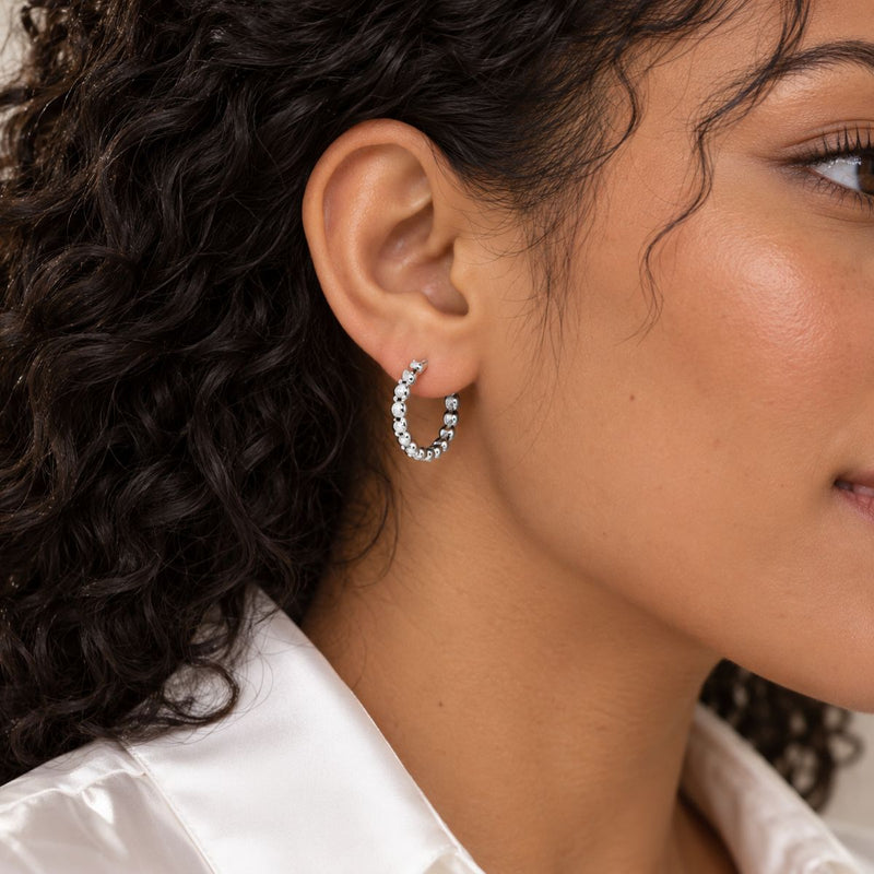 curly black hair model wearing braided earrings