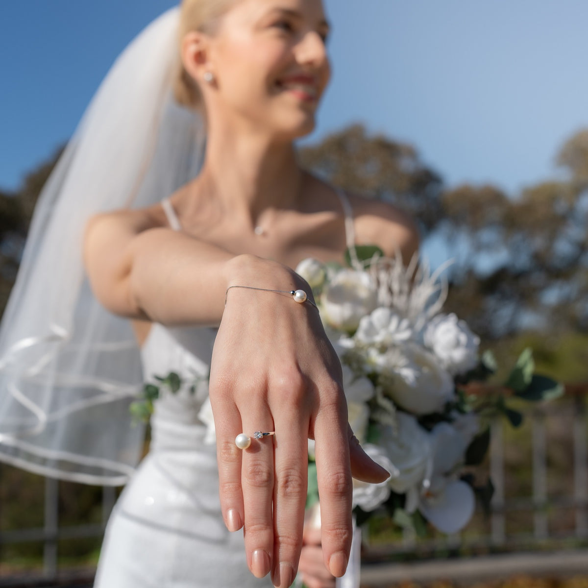 Bride holding a bouquet with a clear focus on her hand and ring.