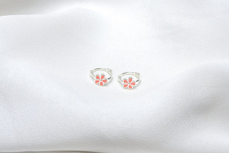 A pair of baby huggies with floral patterns, placed on a white fabric surface.
