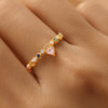 Gold ring with colorful gemstones on a person's finger