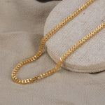 Load image into Gallery viewer, Gold chain on a textured beige surface
