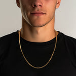 Load image into Gallery viewer, Man wearing a gold chain necklace against a neutral background
