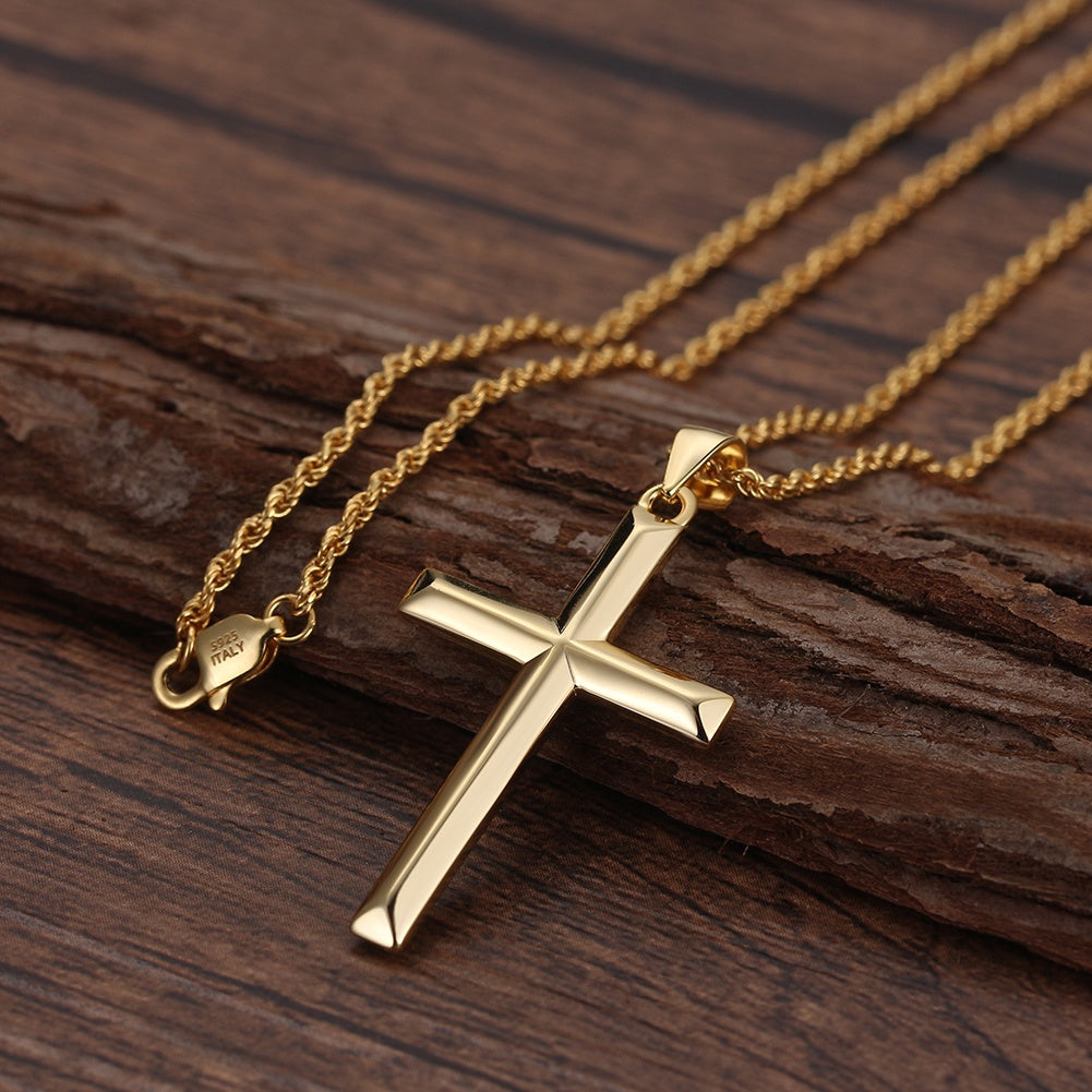 Gold cross necklace on a wooden surface
