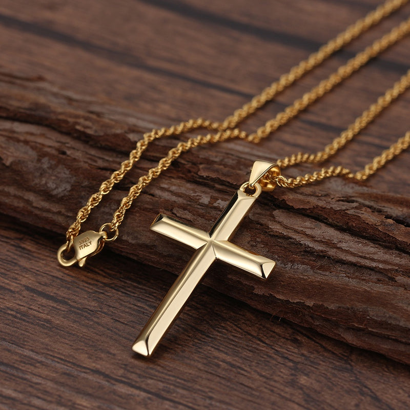 Gold cross necklace on a wooden surface