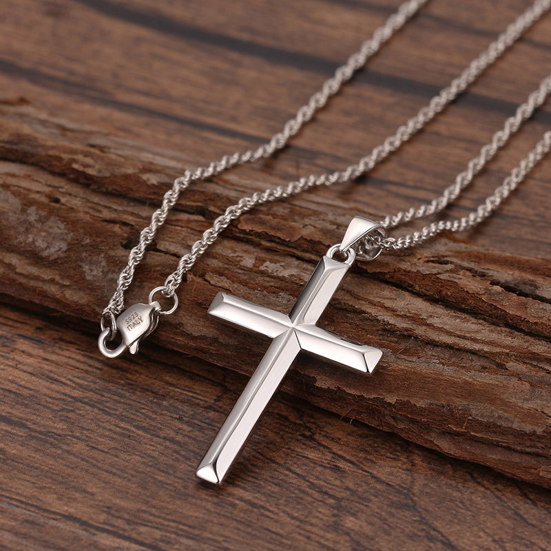 Silver cross necklace on a wooden surface