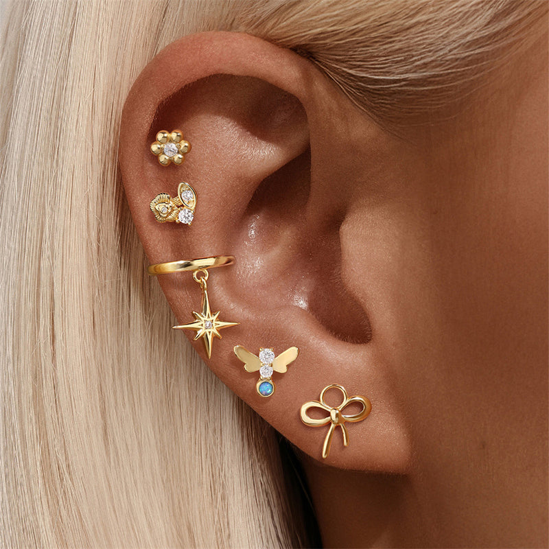 Close-up of an ear with multiple gold earrings