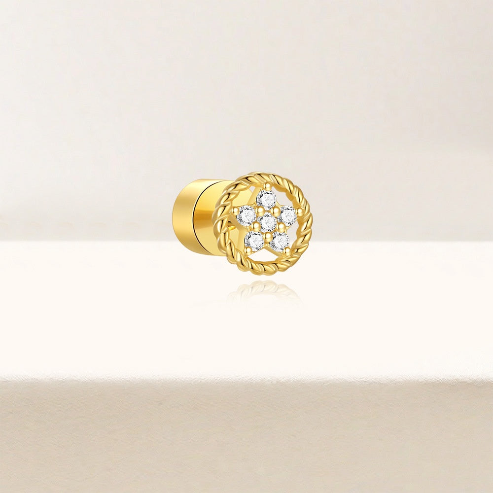 Gold stud earring with floral design on a beige background