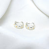 A pair of sterling silver hoop earrings with daisy-shaped embellishments, displayed on a white fabric surface.