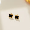 This image displays a pair of elegant Daphne earrings, featuring a simple yet sophisticated design. The earrings are crafted in the shape of clovers, each composed of a single, smooth black stone set within a meticulously crafted gold frame.