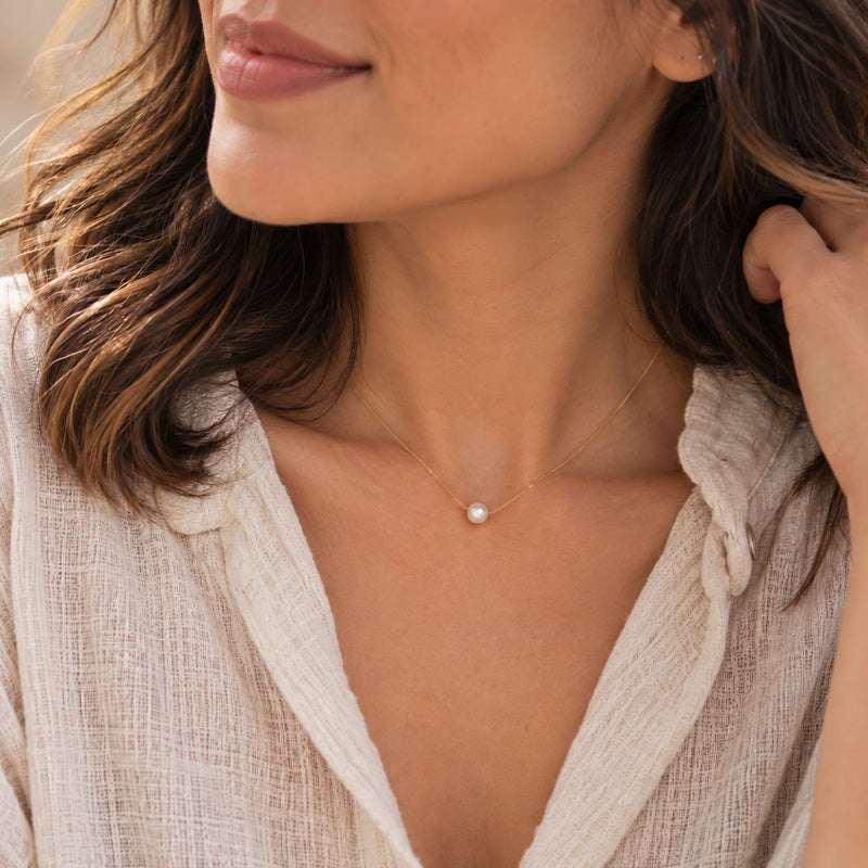 classic pearl necklace around model's neck