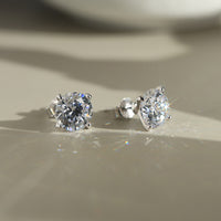 Pair of diamond CZ stud earrings on a neutral background