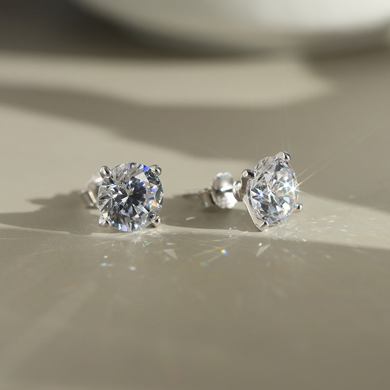 Pair of diamond CZ stud earrings on a neutral background