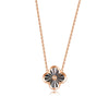 A gold necklace with a floral pendant in the center, resembling a clover leaf, on a white background.