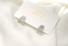 A pair of silver-colored butterfly earrings with a vermeil coating on a white display card with a white background