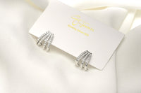A pair of silver-colored butterfly earrings with a vermeil coating on a white display card with a white background
