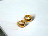 A pair of gold vermeil hoop earrings displayed on a white stone surface.