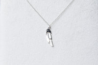A sterling silver necklace with a pendant feather charm, displayed against a white background.