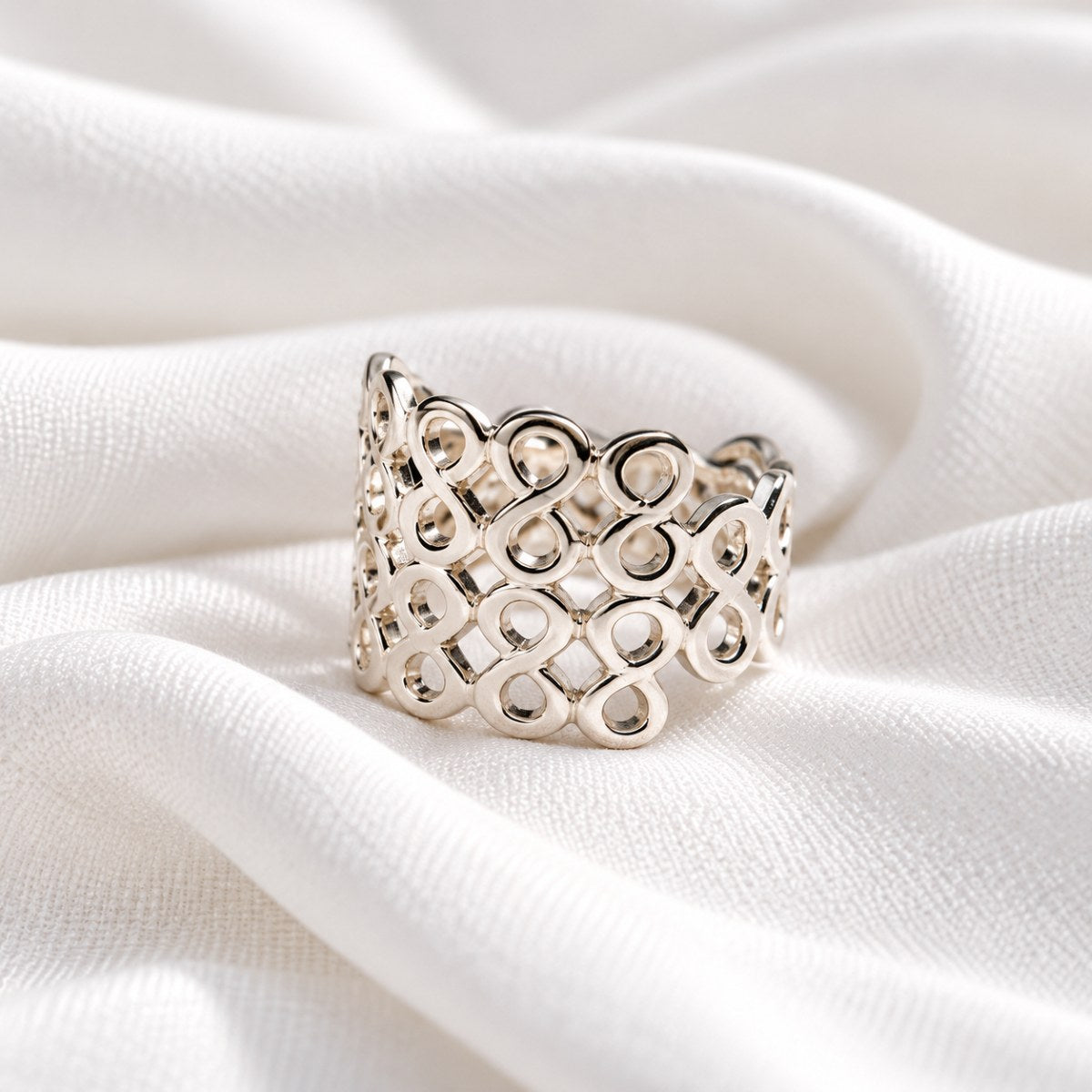 A honeycomb design silver ring on a white background