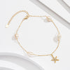 A gold-colored sterling silver anklet with white pearl beads and a star-shaped charm, displayed on a white background.