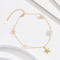 A gold-colored sterling silver anklet with white pearl beads and a star-shaped charm, displayed on a white background.