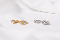 A pair of gold vermeil and sterling silver hoop earrings with diamond cubic zirconia patterns, displayed on a white fabric surface.