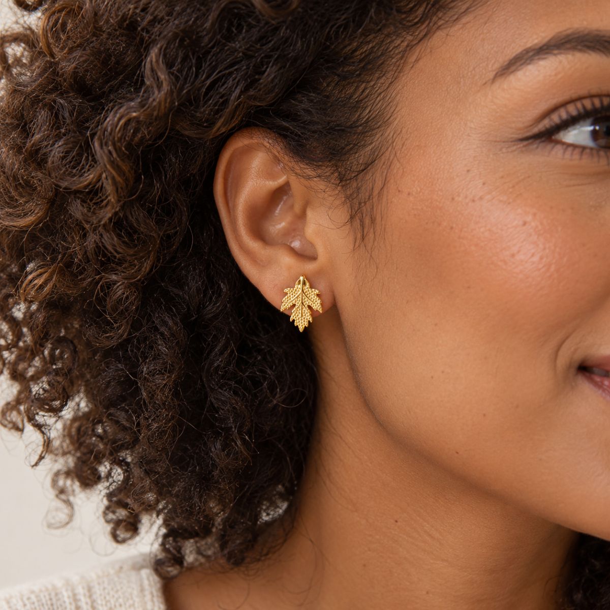 model wearing gold plated maple leaves earrings studs