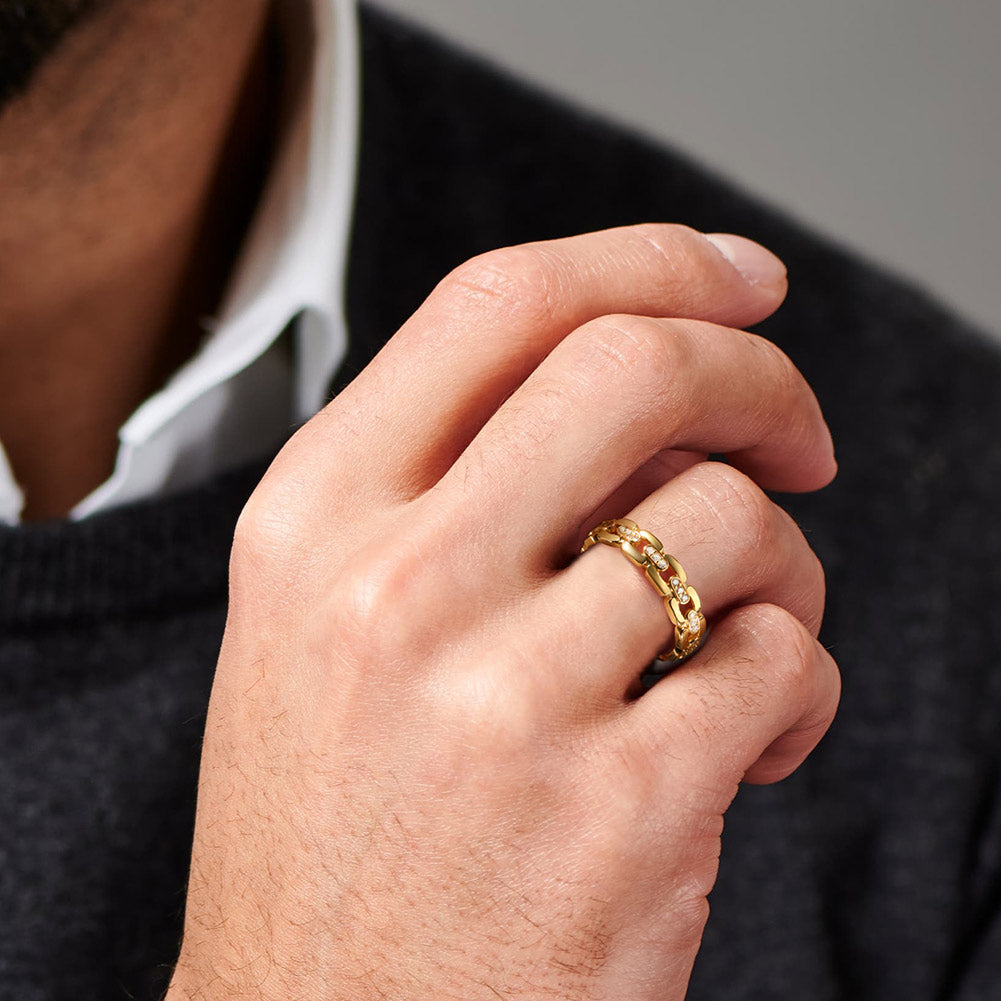 Hand wearing a gold  ring with a blurred background