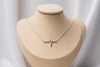 A Silver heartbeat pendant on a silver chain necklace on a bust