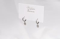 A pair of sterling silver hoop earrings with a floral detail, displayed on a white card with the brand name 'Gaia'.