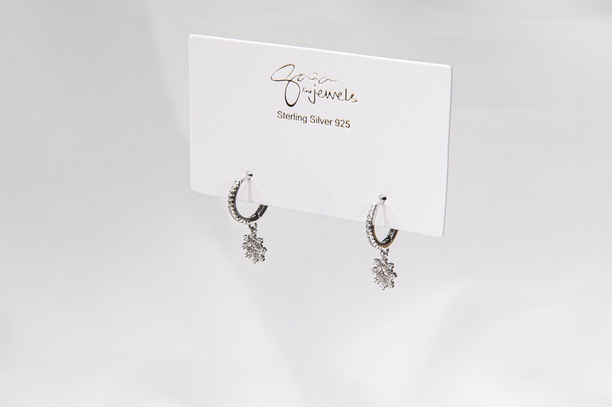 A pair of sterling silver hoop earrings with a floral detail, displayed on a white card with the brand name 'Gaia'.