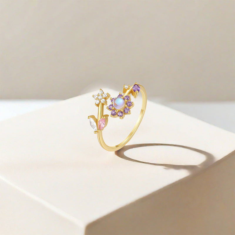 Gold ring with colorful gemstones on a light surface