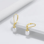 Load image into Gallery viewer, A pair of leverback pearl earrings with a  gold vermeil coating on a white background.
