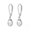 A pair of silver leverback pearl earrings on a white background.