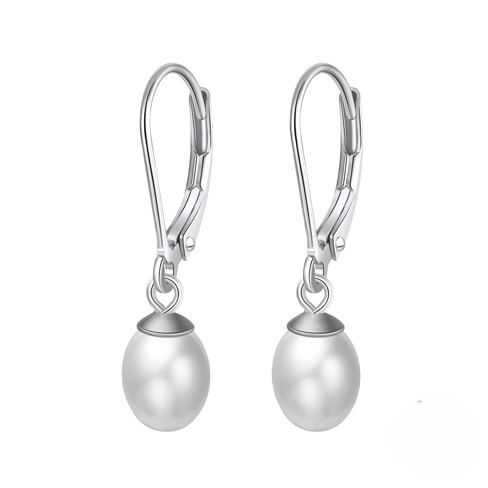 A pair of silver leverback pearl earrings on a white background.