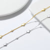 Two anklets, one plated in silver and the other in gold, each featuring a chain with three solid love heart charms.