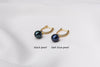 Two pearl earrings featuring gold vermeil. One has a black pearl, one has a dark blue pearl. On a white background with labelling for each different color.