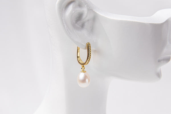 A gold vermeil earring with a pearl displayed on a white mannequin head