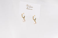 A pair of gold vermeil earings with cuic zirconias and champagne pearls on a white display card and white background
