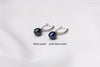 Two pearl earrings featuring silver. One has a black pearl, one has a dark blue pearl. On a white background with labelling for each different color.
