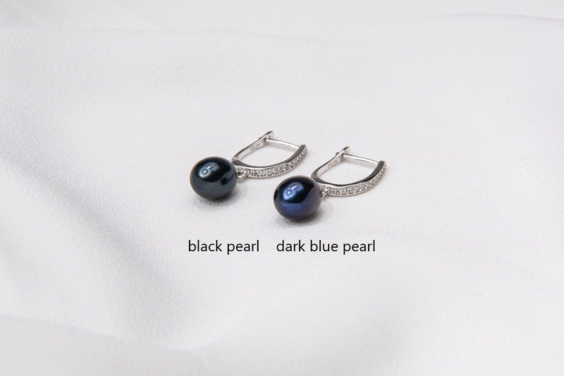 Two pearl earrings featuring silver. One has a black pearl, one has a dark blue pearl. On a white background with labelling for each different color.