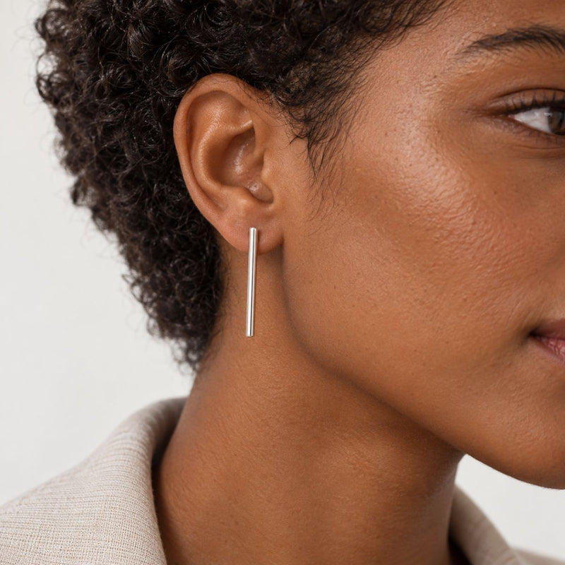 a model wearing the straight forward long bar earrings