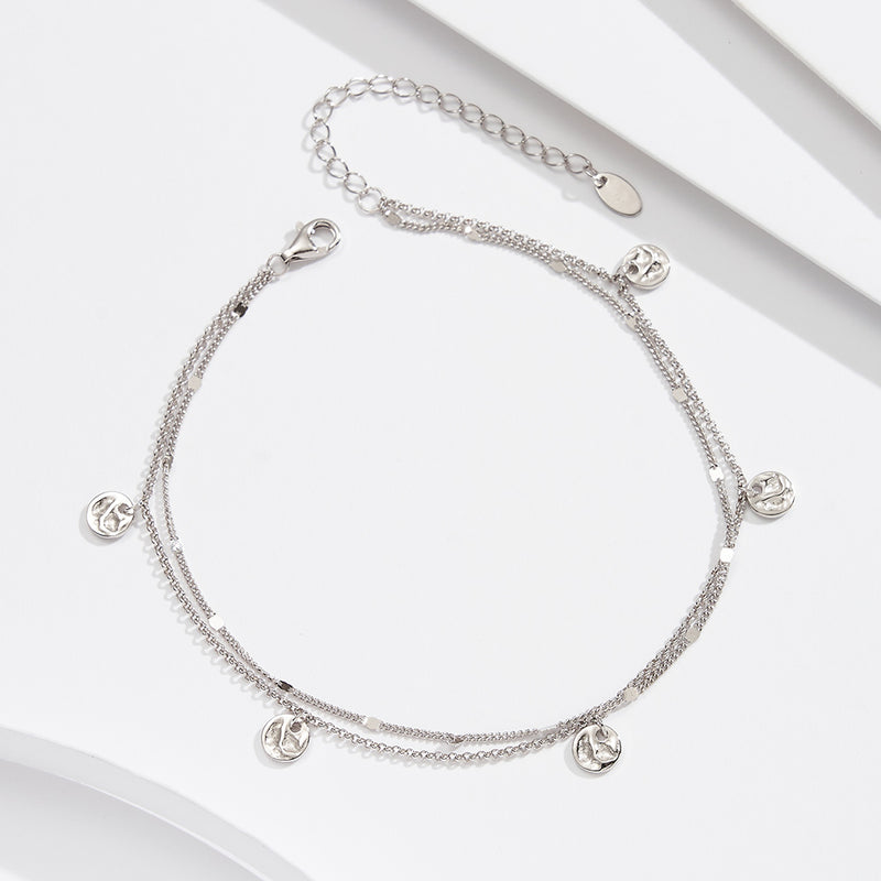 Silver anklet featuring small round pendants