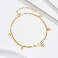 Gold anklet featuring small round pendants
